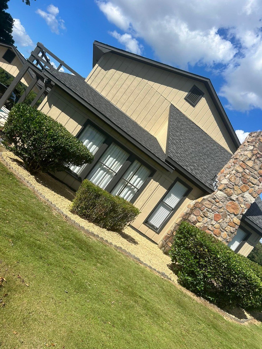 Trimmed shrubs and rock beds in front of a home